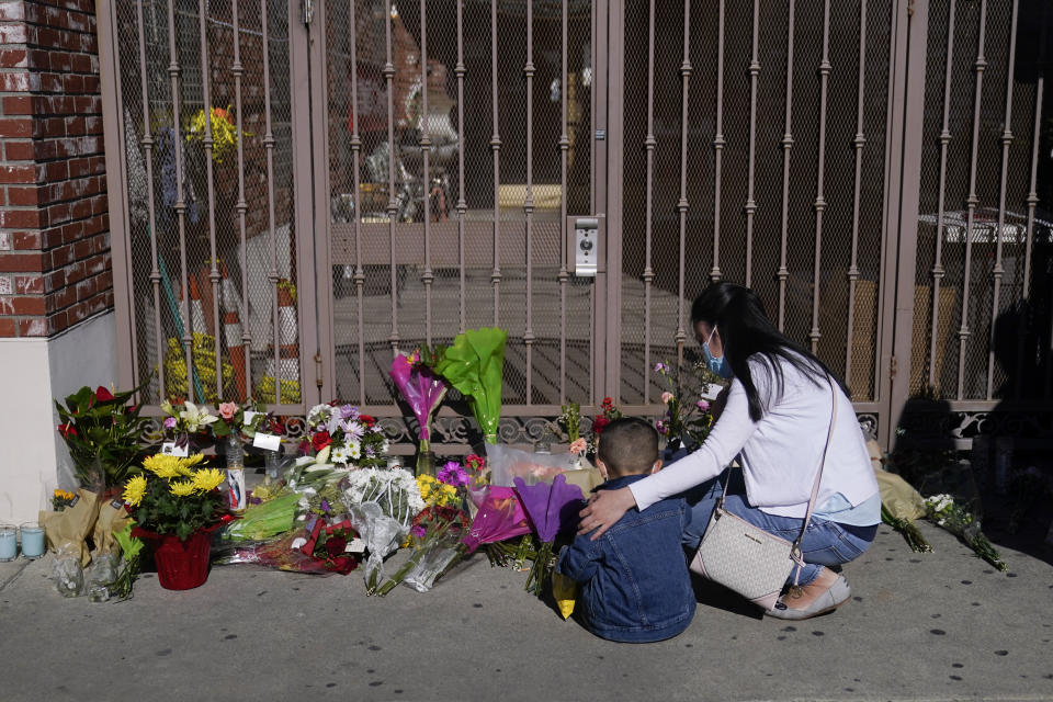 A woman comforts her son while visiting a makeshift memorial outside Star Ballroom Dance Studio in Monterey Park, Calif., Monday, Jan. 23, 2023. Authorities searched for a motive for the gunman who killed multiple people at the ballroom dance studio during Lunar New Year celebrations. (AP Photo/Jae C. Hong)
