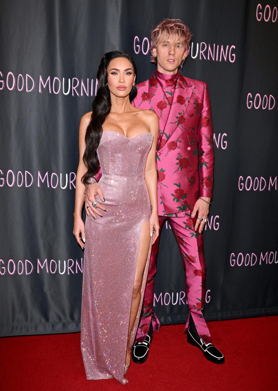 Megan Fox in a metallic pink dress and Machine Gun Kelly in a floral pink suit on the red carpet