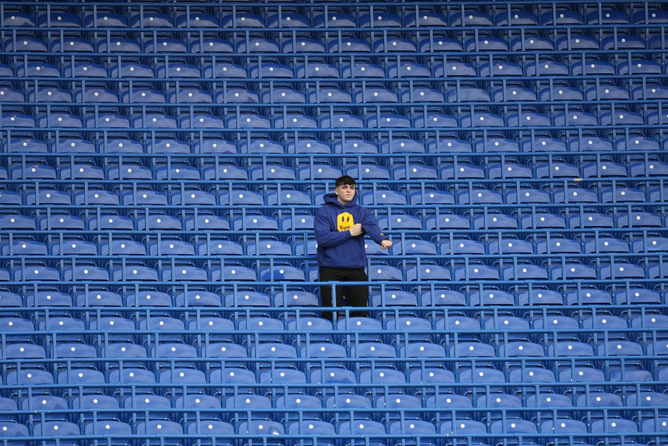 A spectator take his pace in the stands ahead of the English Premier League soccer match between Chelsea and Liverpool at Stamford Bridge in London, Sunday, Jan. 2, 2022. (AP Photo/Matt Dunham)