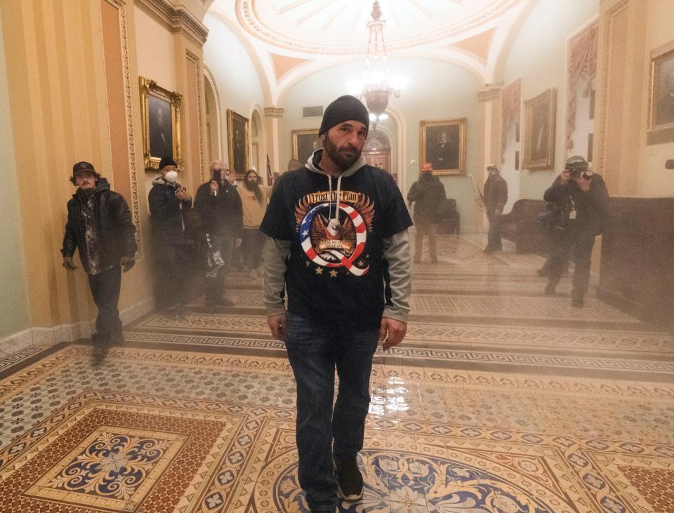 Doug Jensen of Des Moines walks through a smoke-filled hallway outside the Senate Chamber in the U.S. Capitol during the, Jan. 6, 2021, riot in Washington.
