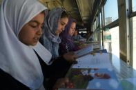 Afghan children read books in a mobile library on a converted bus in Kabul