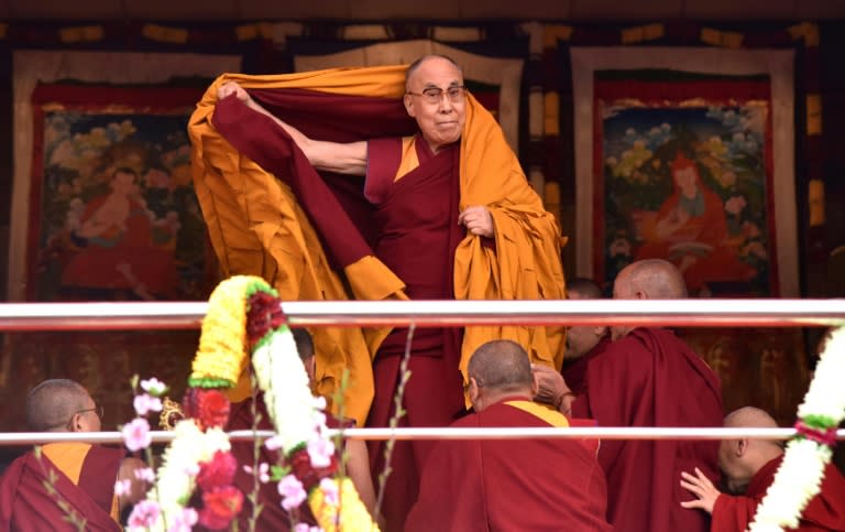 Exiled Tibetan spiritual leader the Dalai Lama adjusts his shawl as he arrives to deliver teachings to Buddhist followers at the Yiga Choezin ground in Tawang near the India-China border