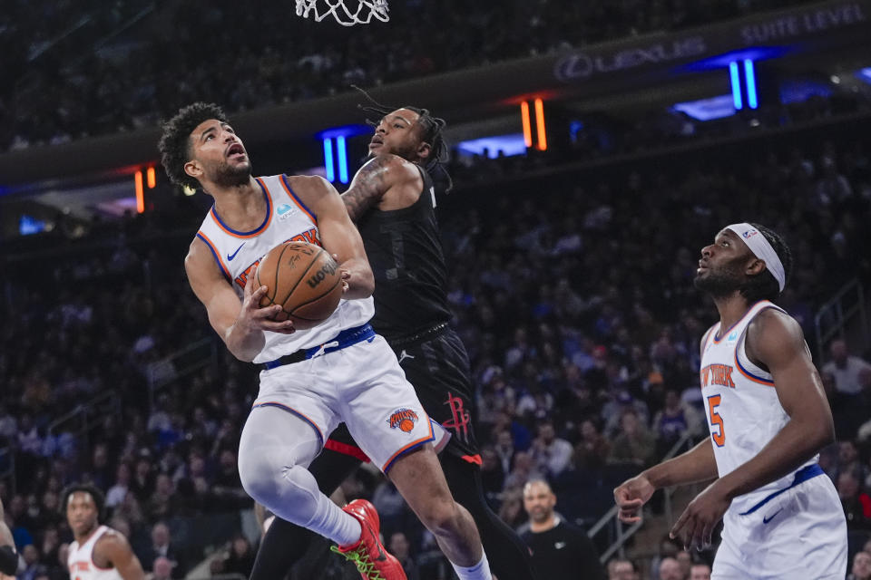 New York Knicks guard Quentin Grimes, left, goes to the basket against Houston Rockets forward Cam Whitmore in the first half of an NBA basketball game, Wednesday, Jan. 17, 2024, at Madison Square Garden in New York. (AP Photo/Mary Altaffer)