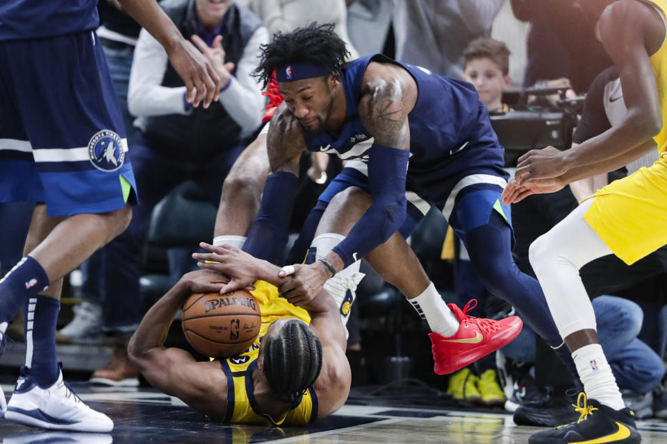 Minnesota Timberwolves forward Robert Covington, top, forces a jump ball with Indiana Pacers forward T.J. Warren during the second half of an NBA basketball game in Indianapolis, Friday, Jan. 17, 2020. The Pacers won 116-114. (AP Photo/Michael Conroy)