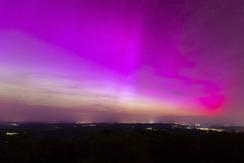 Northern lights appear in the night sky over the Pferdskopf near Treisberg in the Hochtaunus district of Hesse, Germany, early Saturday, May 11, 2024. (Lando Hass/dpa via AP)