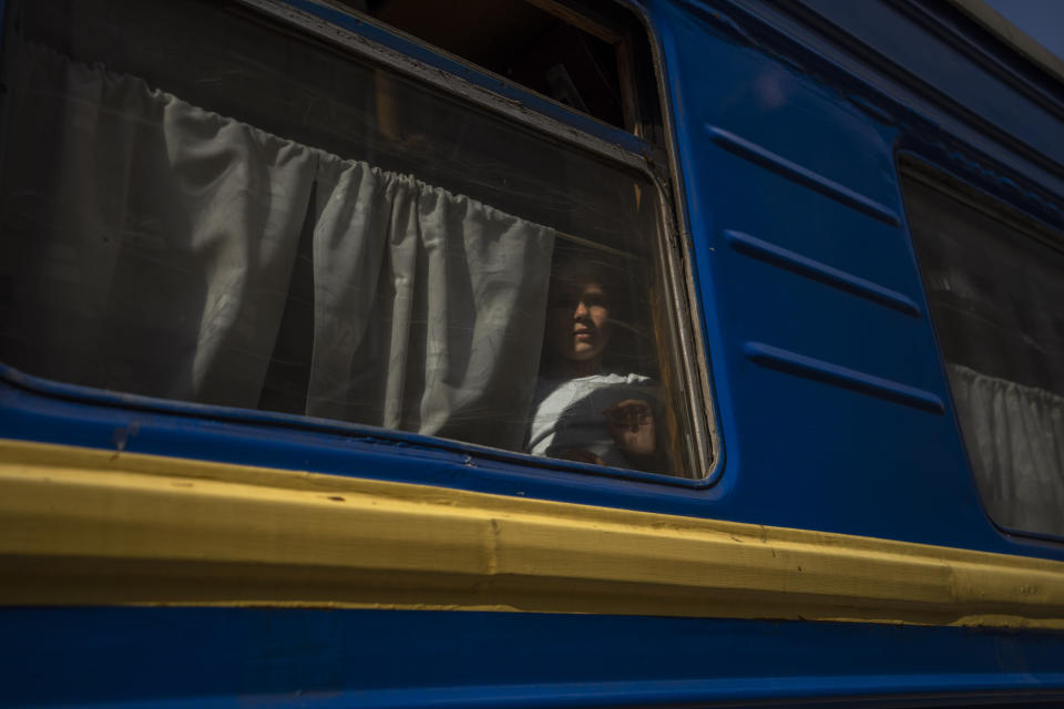 An internally displaced girl looks out the window of a train heading to Dnipro, in the Pokrovsk train station, Donetsk region, eastern Ukraine, Wednesday, July 6, 2022. Many are responding to the authorities' pleas to evacuate. As Russian troops march west, a steady flow of people continue to evacuate from towns caught in the crosshairs of the war, with hundreds leaving on a daily evacuation train from Pokrovsk. (AP Photo/Nariman El-Mofty)