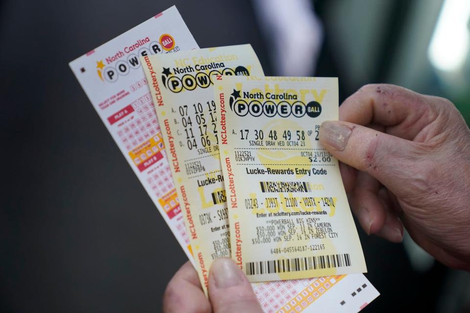 A customer holds Powerball tickets purchased in North Carolina in October 2023.