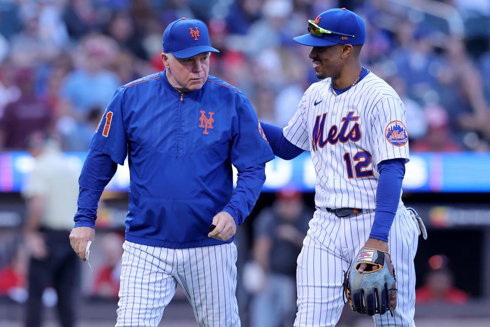 Oct 1, 2023; New York City, New York, USA; New York Mets shortstop Francisco Lindor (12) puts his arm around manager Buck Showalter (11) as he walks off the field after making a pitching change during the ninth inning against the Philadelphia Phillies at Citi Field.