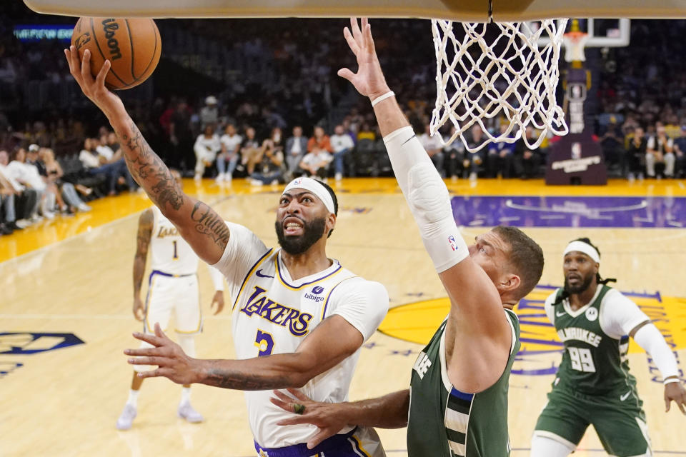 Los Angeles Lakers forward Anthony Davis, left, shoots as Milwaukee Bucks center Brook Lopez defends during the first half of an NBA preseason basketball game Sunday, Oct. 15, 2023, in Los Angeles. (AP Photo/Mark J. Terrill)