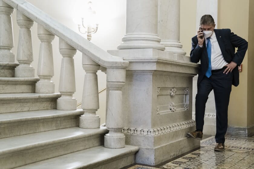 WASHINGTON, DC - JANUARY 19: Sen. Joe Manchin (D-WV) on a phone call in a hallway just outside the Senate Chamber, after speaking on the floor of the Senate, on Capitol Hill on Wednesday, Jan. 19, 2022 in Washington, DC. The Senate heads towards a vote on whether or not to enact sweeping voting rights reforms. (Kent Nishimura / Los Angeles Times)