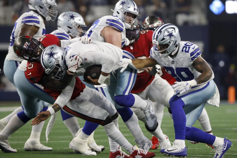 Tampa Bay Buccaneers linebacker Devin White, left, sacks Dallas Cowboys quarterback Dak Prescott (4) as Tony Pollard (20) looks on in the second half of a NFL football game in Arlington, Texas, Sunday, Sept. 11, 2022. (AP Photo/Michael Ainsworth)