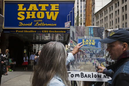 A fan talks about his painting outside of Ed Sullivan Theater in Manhattan as David Letterman prepares for the taping of tonight's final edition of "The Late Show" in New York May 20, 2015. REUTERS/Lucas Jackson