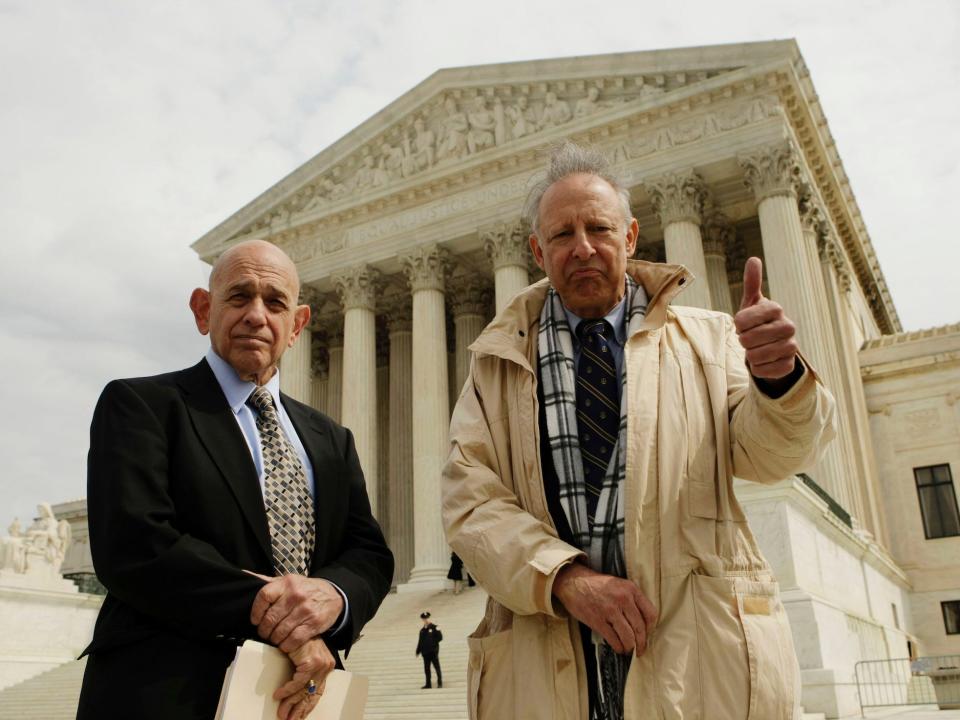 Dick Anthony Heller, 65, right, gives a "thumbs-up" as he stands with Robert A. Levy, left, from the Cato Institute, outside the Supreme Court in Washington, Tuesday, March 18, 2008,
