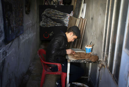 Ninos Thabet, an 18-year-old Christian who studied art at Mosul University, creates miniature replicas of statues destroyed by militants when they overran the 3,000-year-old Assyrian city of Nimrud 2-1/2 years ago, in Erbil, Iraq, January 13, 2017. Picture taken January 13, 2017. REUTERS/Girish Gupta