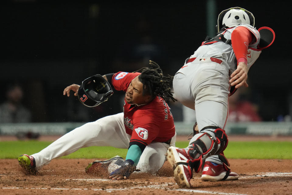 Cleveland Guardians' Jose Ramirez, left, scores safely behind Cincinnati Reds catcher Tyler Stephenson, right, in the fifth inning of a baseball game in Cleveland, Tuesday, Sept. 24, 2024. (AP Photo/Sue Ogrocki)