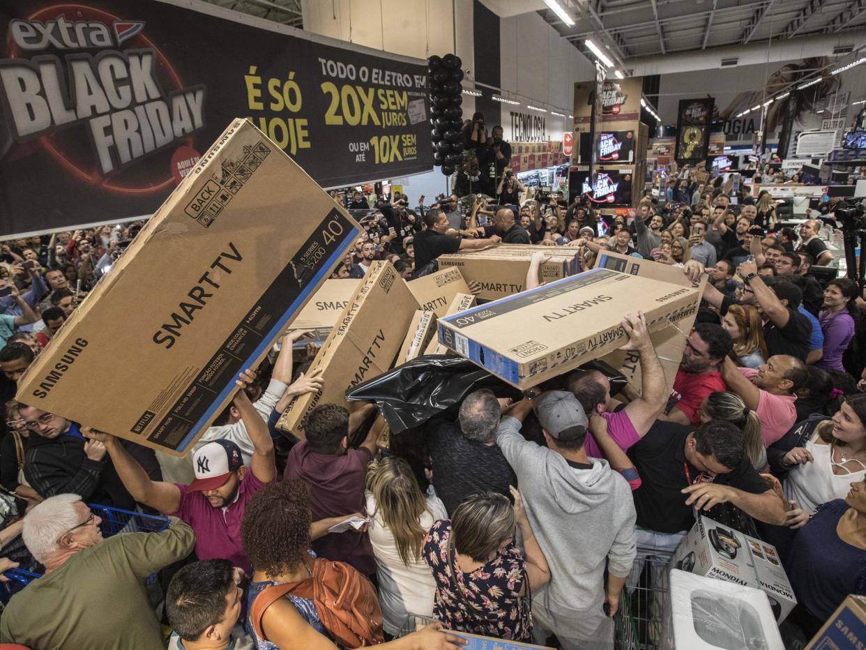 Dozens of Brazilians reach for television sets in a store in Sao Paulo, Brazil (EPA)