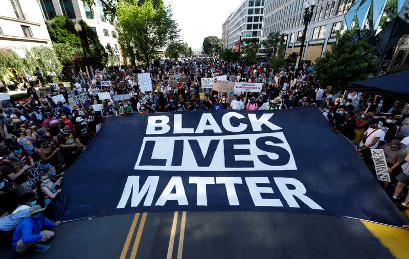 Manifestantes sostienen un cartel gigante en la Plaza Black Lives Matter, cerca de la Casa Blanca, durante una protesta contra la desigualdad racial después de la muerte de George Floyd bajo custodia policial en Mineápolis, en Washington.