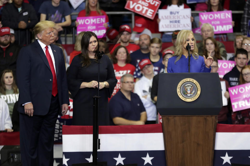 President Donald Trump and press secretary Sarah Huckabee Sanders listen as White House senior adviser Kellyanne Conway speaks at a campaign rally at the Allen County War Memorial Coliseum in Fort Wayne, Ind., Monday, Nov. 5, 2018. (AP Photo/Michael Conroy)