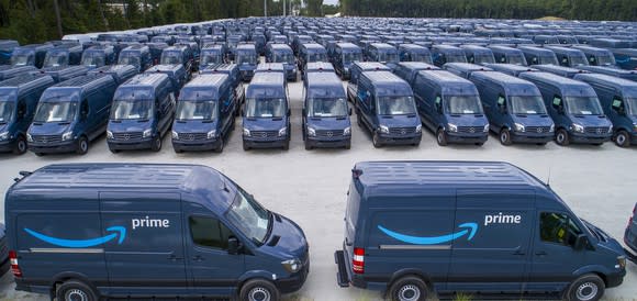 Fleet of blue vans with Amazon logo and word Prime on them.