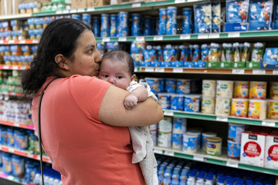 Yury Navas, 29, of Laurel, Md., kisses her two-month-old baby Ismael Galvaz, at Superbest International Market in Laurel, Md., Monday, May 23, 2022, while looking for formula. After this day's feedings she will be down to the last 12.5 ounce container. The only formula he can take without digestive issues, Enfamil Infant, has been almost impossible for her to find. Navas doesn't know why her breastmilk didn't come in for her third baby and has tried many brands of formula before finding the one kind that he could tolerate. Though the baby food aisle had plenty of options for older babies, the kind she needs was nowhere in sight. (AP Photo/Jacquelyn Martin)