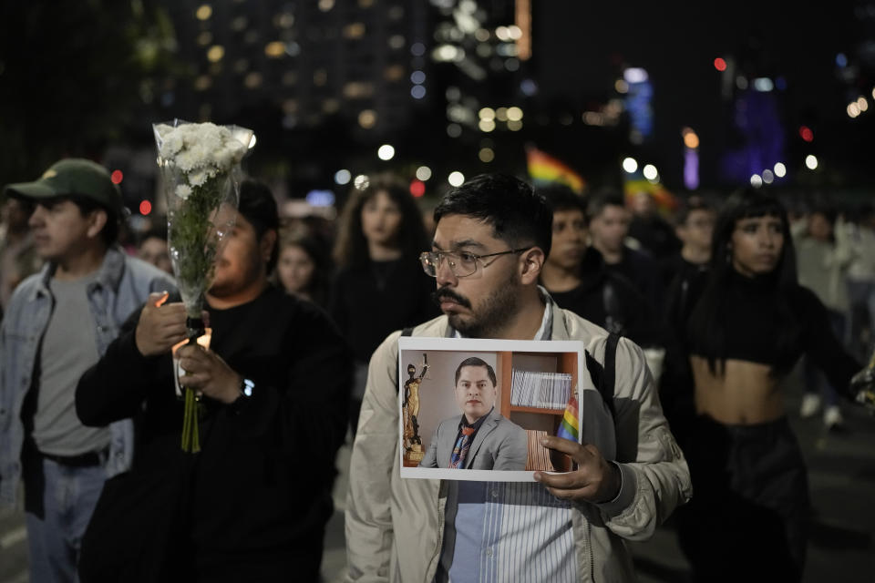 A demonstrator holds a picture of Aguascalientes state electoral court magistrate Jesus Ociel Baena in Mexico City, Monday, Nov. 13, 2023. The first openly nonbinary person to assume a judicial position in Mexico was found dead in their home Monday in the central Mexican city of Aguascalientes after receiving death threats because of their gender identity, authorities said. (AP Photo/Eduardo Verdugo)