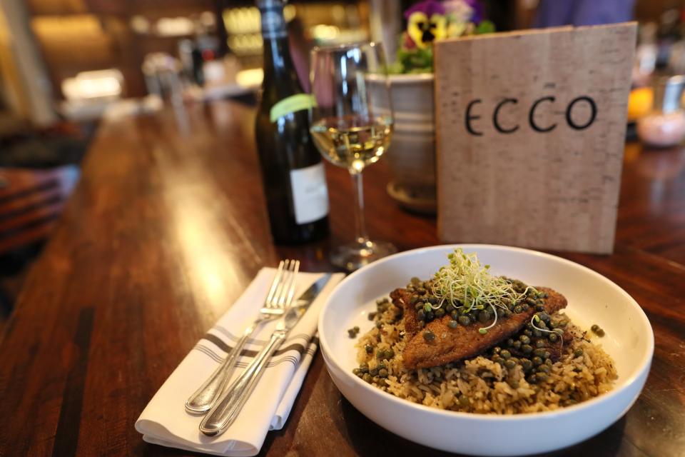 Branzino bass filet served with lemon and caper butter over basmati rice at Ecco in Midtown's Evergreen Historic District.
