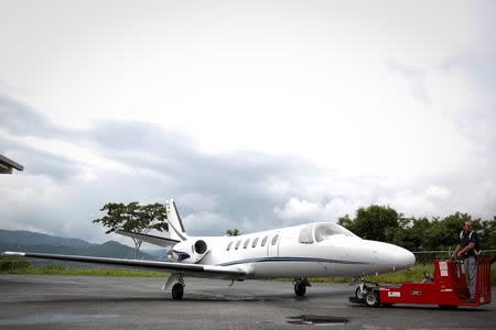 A private plane is towed by a worker before takeoff at Charallave airport outside Caracas September 15, 2014. REUTERS/Carlos Garcia Rawlins