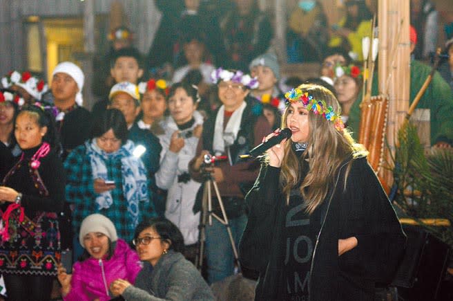 阿妹2015年頭戴花環、拿起麥克風歡迎參加年祭的遊客，但也呼籲遊客不要一直拿手機拍照。（本報資料照片）