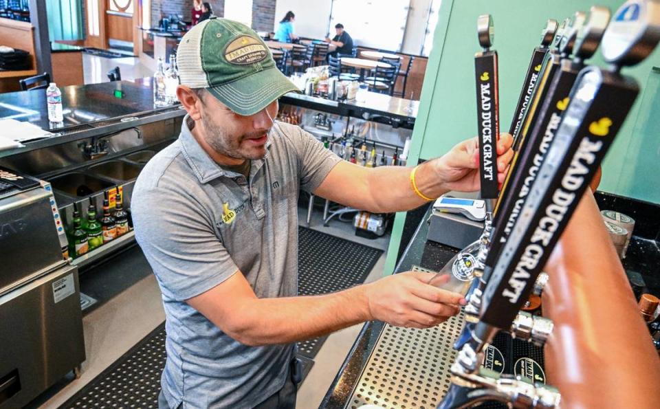 Alex Costa, one of the owners of Mad Duck, pulls a tap for a draft beer at the Fresno brewery and restaurant’s fourth location at Copper and Maple in north Fresno on Friday, April 12, 2024. CRAIG KOHLRUSS/ckohlruss@fresnobee.com