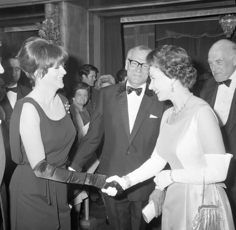 <p>Before she was damed by the Queen, Maggie Smith met the monarch at a charity premiere for her film <em>Othello</em>. Maggie wore a sophisticated black evening dress and a jeweled broach for the occasion, as one does.</p>