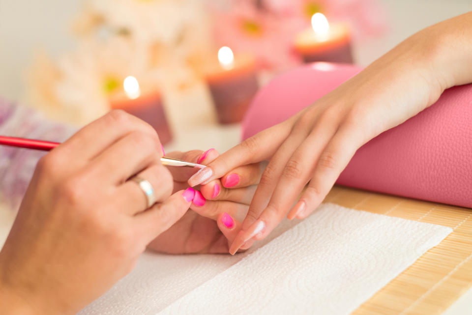 Manicurist applying nail polish during a manicure