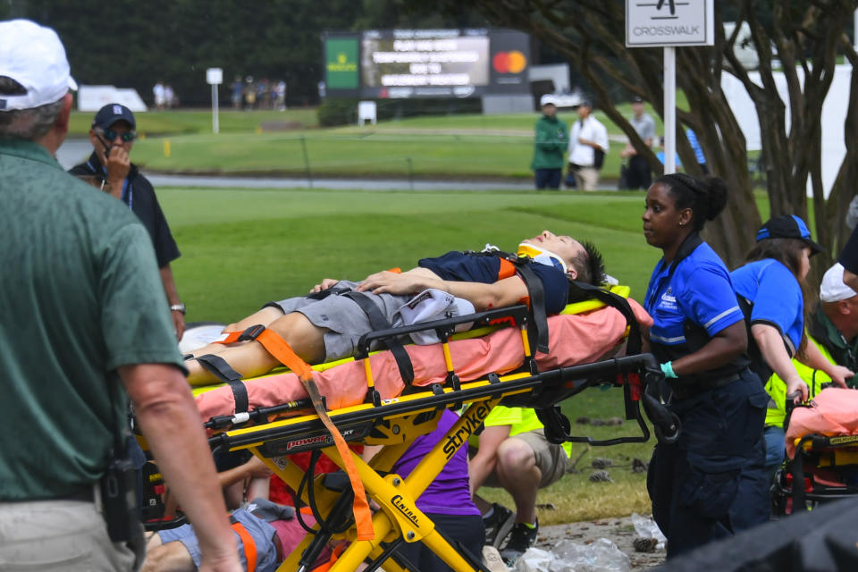 A spectator is taken to an ambulance after a lightning strike on the course which left several injured during a weather delay in the third round of the Tour Championship golf tournament Saturday, Aug. 24, 2019, in Atlanta. (AP Photo/John Amis)