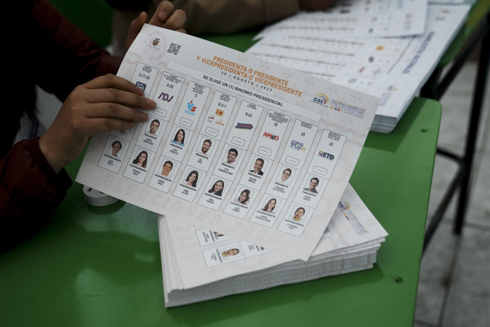 An electoral official shows the ballot for a presidential election in Ayora, Ecuador, Sunday, Aug. 20, 2023. The election was called after President Guillermo Lasso dissolved the National Assembly by decree in May to avoid being impeached. (AP Photo/Dolores Ochoa)