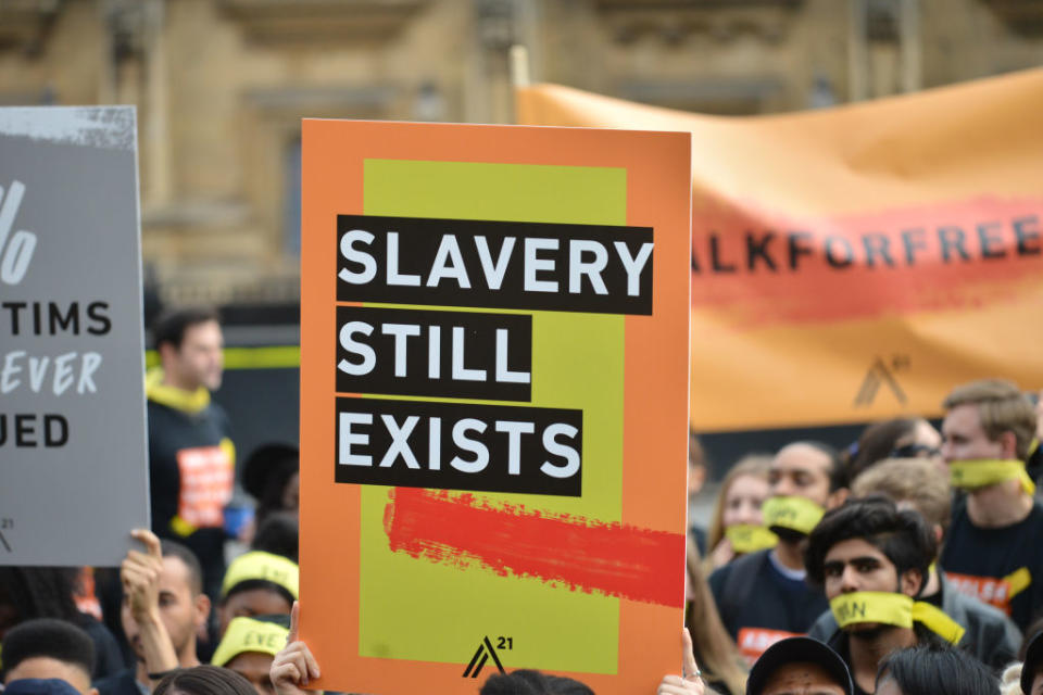 People marching against modern slavery through London wearing face masks representing the silence of modern slaves in forced labour and sexual exploitation on October 14, 2017 in London, England. | Barcroft Media via Getty Images—Mathew Chattle / Barcroft Media