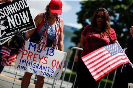 U.S. president Trump supporter holds a banner against MS-13 before a forum about Central American-based Mara Salvatrucha (MS-13) gang organization at the Morrelly Homeland Security Center in Bethpage, New York, U.S., May 23, 2018. REUTERS/Eduardo Munoz