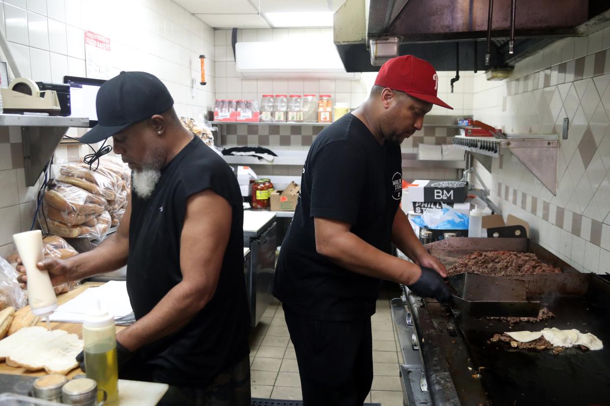 Co-owner Jamar "Marlow" Sheppard (right) and Eddie Finch prepare an order May 10 at Marlow's Cheesesteaks & The Water Ice Shoppe, 93 N. High St. in Gahanna.