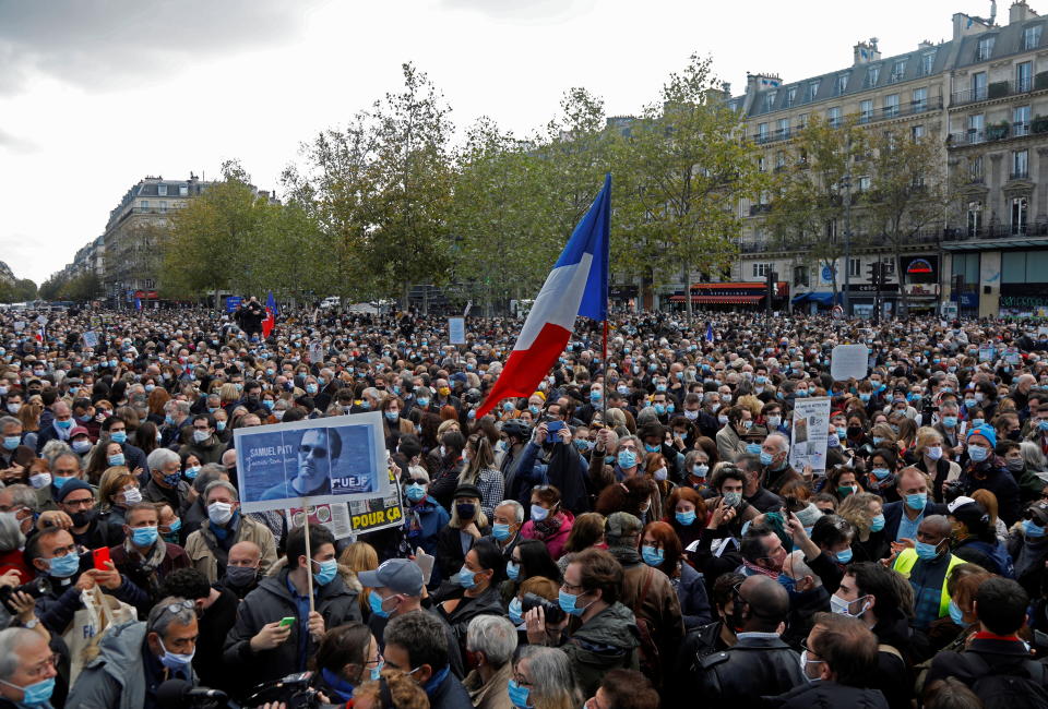 People gather at the Place de la Republique in Paris, to pay tribute to Samuel Paty, the French teacher who was beheaded on the streets of the Paris suburb of Conflans-Sainte-Honorine, France, October 18, 2020. REUTERS/Charles Platiau