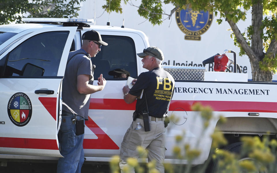 Agents from the FBI and Fremont County Emergency Management Office confer at the scene of the Return to Nature Funeral Home on Monday, Oct. 9, 2023, where over 100 decomposing bodies were found last week in Penrose, Colo. (Jerilee Bennett/The Gazette via AP)