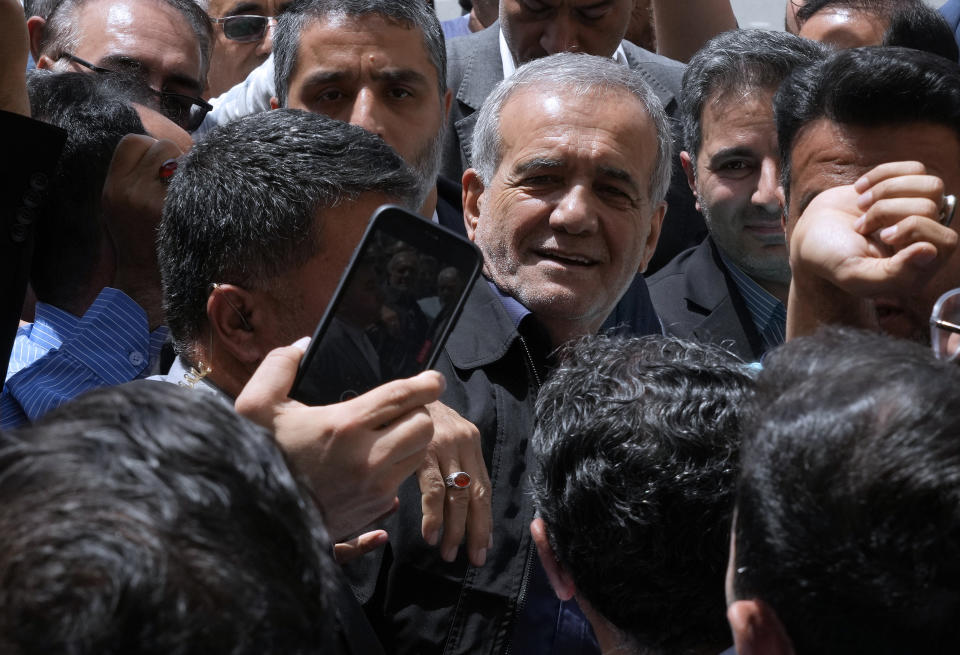 Reformist candidate for the Iran's presidential election Masoud Pezeshkian is greeted by his supporters as he arrives to vote at a polling station in Shahr-e-Qods near Tehran, Iran, Friday, July 5, 2024. Iranians are voting in a runoff election to replace the late President Ebrahim Raisi, who was killed in a May helicopter crash in the country’s northwest along with the foreign minister and several other officials. (AP Photo/Vahid Salemi)