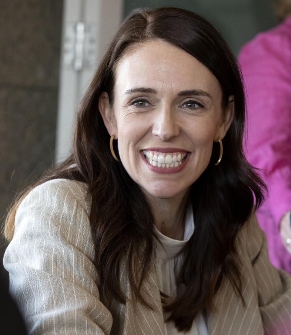 New Zealand Prime Minister Jacinda Ardern reacts as she talks with colleagues at a cafe in Auckland, New Zealand, Sunday, Oct. 18, 2020. Ardern has won a second term in office in an election landslide of historic proportions. (AP Photo/Mark Baker)