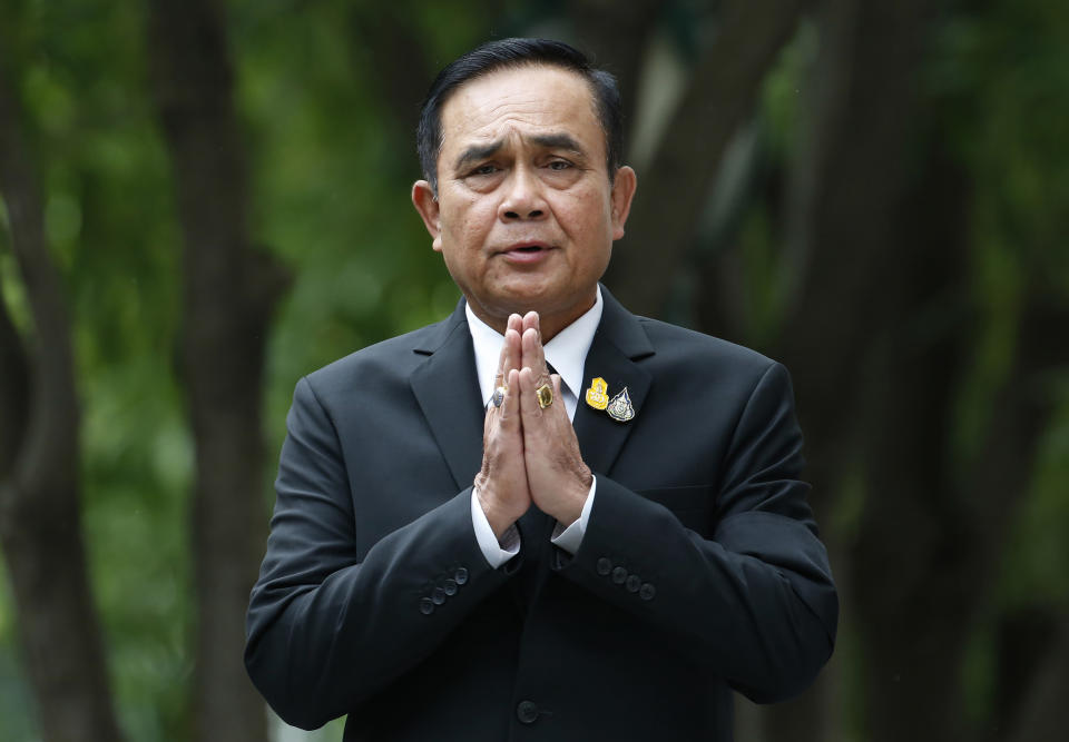 FILE - In this Thursday, June 6, 2019, file photo, Thailand's Prime Minister Prayuth Chan-ocha gives the traditional greeting, or "wai," as he talks to reporters before a meeting at the government house in Bangkok, Thailand. The leader of Thailand's military government has revoked a number of special executive legal orders and vowed to stop issuing more as he prepares to lead the next elected civilian government. (AP Photo/Sakchai Lalit, File)