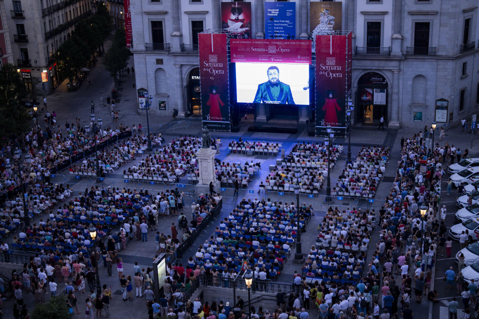 Opera fans and passers-by watch Giacomo Puccini's Turandot opera on a giant screen in a square outside Teatro Real opera house in Madrid, Spain, Friday, July 14, 2023. For the past eight years, Madrid’s Teatro Real opera house has held a week of opera broadcasting shows that have been staged in the theater to towns and cities around Spain for free. The aim is to try to spread interest in the art form among the public and rid it off its elitist tag. This July, the highlight was Giacomo Puccini’s masterpiece, Turandot. (AP Photo/Bernat Armangue)