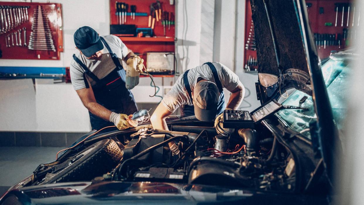 Two man working on repair of old timer.