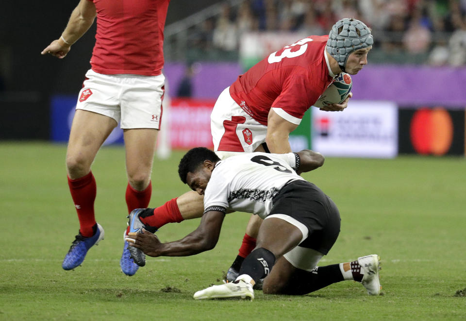 Wales' Jonathan Davies is tackled by Fiji's Frank Lomani during the Rugby World Cup Pool D game at Oita Stadium between Wales and Fiji in Oita, Japan, Wednesday, Oct. 9, 2019. (AP Photo/Aaron Favila)