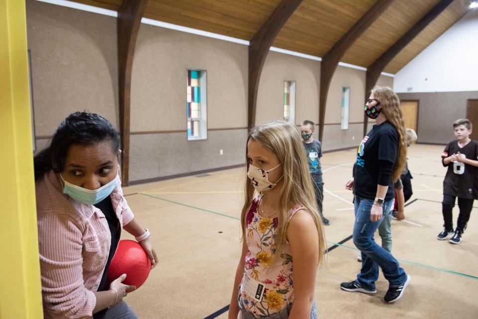 Pastor Monu Shinchoury, left, children's ministry pastor and a native of Bhutan, shares a moment with a girl before her parents pick her up after a service at First Alliance Church.