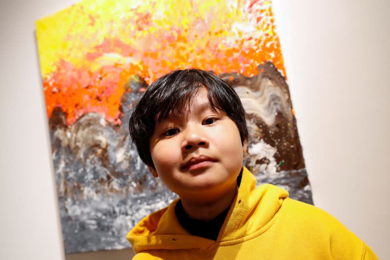 Xeo Chu, a Vietnamese art prodigy, poses in front of one of his pieces before his debut solo exhibition at the Georges Berges Gallery in New York