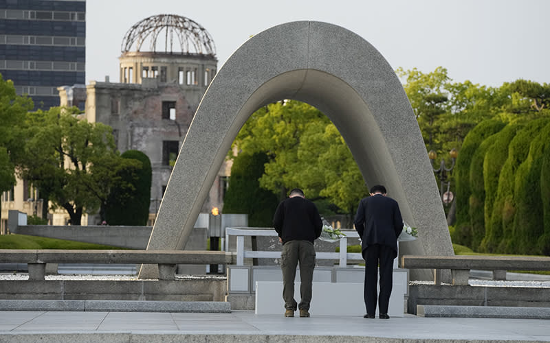Ukrainian President Volodymyr Zelensky and Japanese Prime Minister Fumio Kishida bow before laying flowers in front of a memorial for victims of the atomic bomb