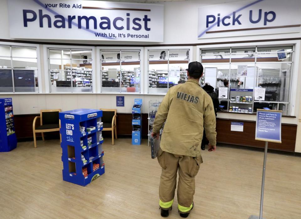 Fire line medic Aaron Thomas waits to pick up prescription medicine at a pharmacy