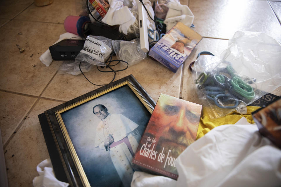 A photo of former Archbishop Anthony Apuron lays among discarded items on the floor of the former Accion Hotel which was a seminary but is now vacant and for sale by the Catholic Church, in Yona, Guam, Wednesday, May 8, 2019. In April the Vatican revealed that Pope Francis had upheld the findings of a secret church trial that found Apuron guilty of sex crimes against children. Anthony Apuron denies the allegations, which are detailed in lawsuits. (AP Photo/David Goldman)