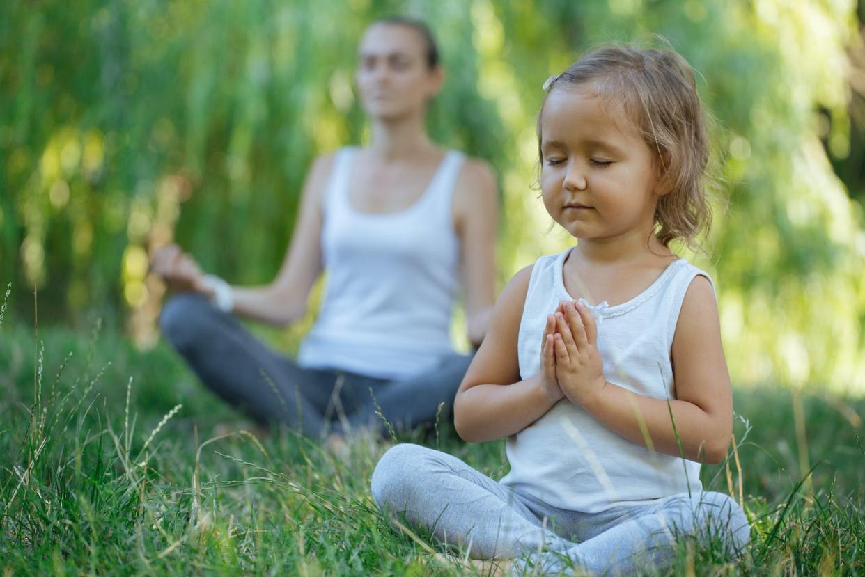 Meditation and mindfulness techiques are becoming increasingly common in school settings. <a href="https://www.gettyimages.com/detail/photo/girl-meditating-with-mother-on-field-royalty-free-image/1002493430?adppopup=true" rel="nofollow noopener" target="_blank" data-ylk="slk:Alexander Egizarov/EyeEm;elm:context_link;itc:0;sec:content-canvas" class="link ">Alexander Egizarov/EyeEm</a>